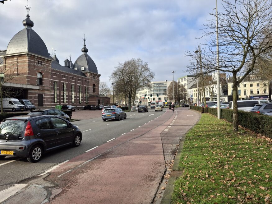 Rode fietsstrook tussen rechtdoorgaande autoweg en rechtsafslaande afrit.